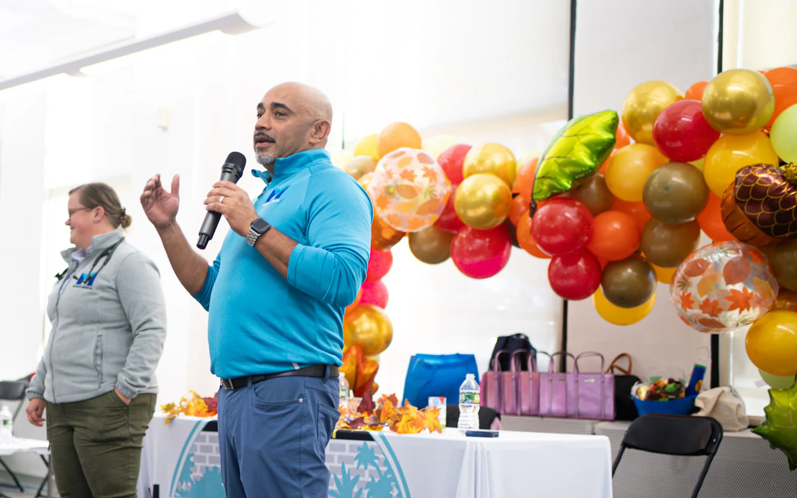 John Johnson speaks at the Hunts Point breast cancer awareness event, with Dr. Michelle Benrimon beside him.