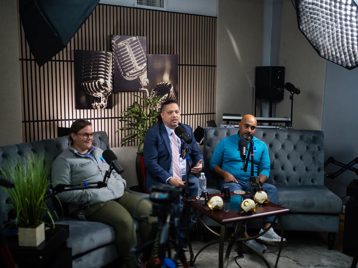 Wide view of the I Axis Radio studio during the show, with Dr. Benrimon, the host and John Johnson seated at microphones